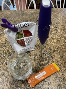 MetaPWR supplement, fiber supplements, frother, and glass of water